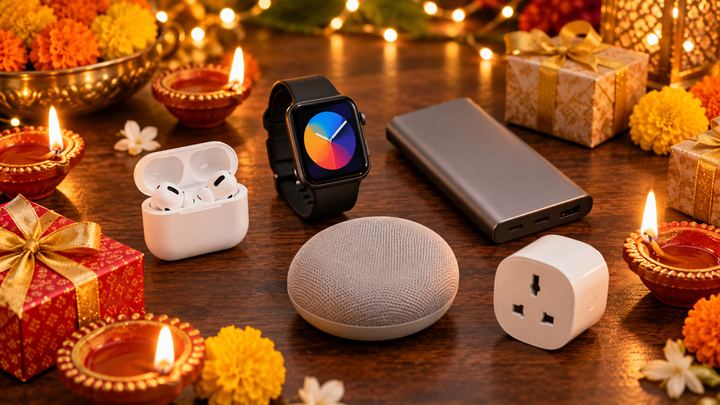Wireless earbuds, a smartwatch, a power bank, a Bluetooth speaker and a smart plug on a table with diyas, marigolds and Diwali gift boxes