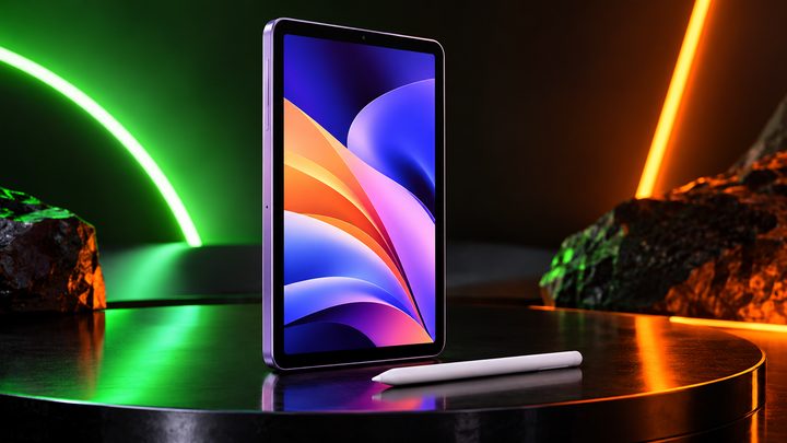 A small lavender tablet with a colourful wallpaper and a white stylus on a dark stage lit by green and orange neon